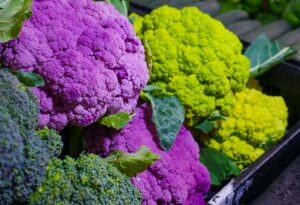 Article: Cauliflower companion plants. Some purple and some green cauliflowers