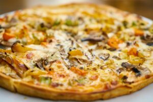Article: Oregano Companion Plants. Pic - Pizza with lots of toppings and herbs