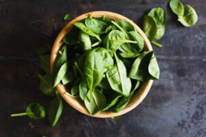 Article: Spinach companion plants. small spinach leaves in an earthen bowl