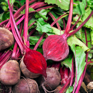 Freshly harvested beetroots with vibrant red stems and lush green leaves.