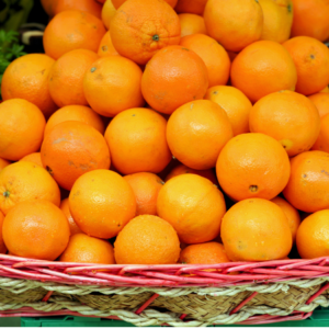 : A basket filled with a large number of fresh oranges, stacked neatly.