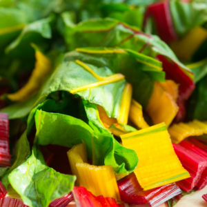 Close-up of chopped Swiss chard, displaying vibrant green leaves and colorful red and yellow stems.