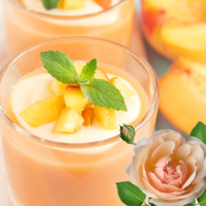 Article : Growing Peach Trees in Pots. Pic - Close-up of a peach dessert in a glass, topped with fresh peach chunks and mint leaves, with whole peaches and a rose in the background.